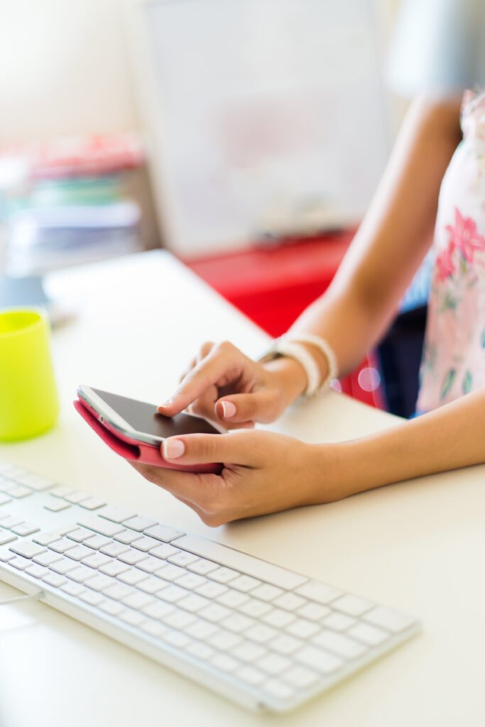 faceless-female-using-smartphone-near-computer